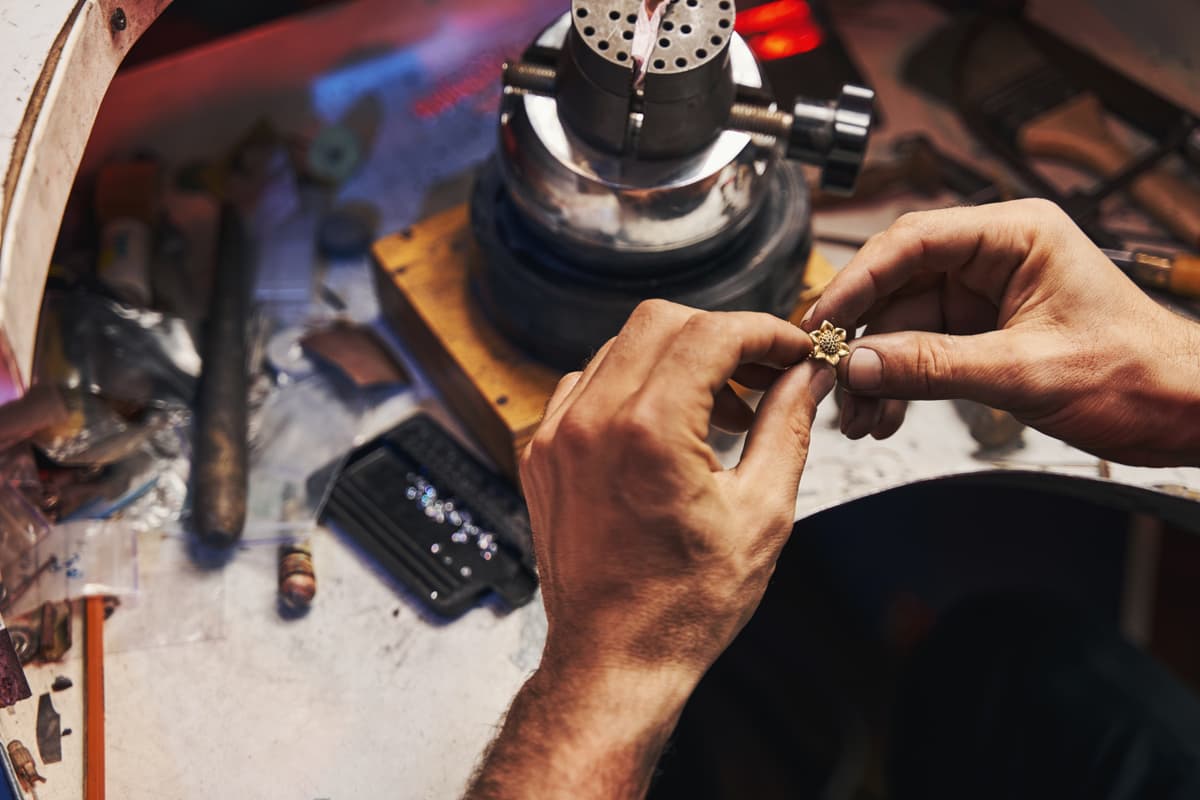 Jewelry manufacturing workshop with craftspeople creating custom jewelry pieces
